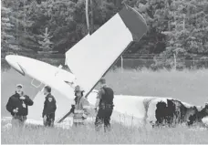  ?? RASHAH MCCHESNEY, PENINSULA CLARION, VIA AP ?? Police and emergency personnel stand near a fixed- wing aircraft that crashed Sunday at an airport in Soldotna, Alaska.