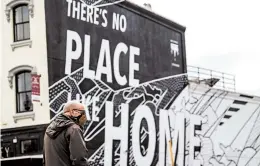  ?? ANDREW HARNIK/AP ?? A man walks by a “There’s No Place Like Home” mural in Washington, D.C., which President Trump wants reopened. The nation’s capital is easing its stay-at-home order this week.