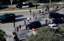  ?? PHOTO ?? In this Feb. 14 file photo, students hold their hands in the air as they are evacuated by police from Marjory Stoneman Douglas High School in Parkland, Fla., after a shooter opened fire on the campus. AP