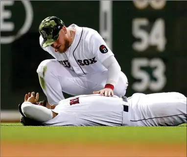  ?? AP PHOTO BY MICHAEL DWYER ?? Boston Red Sox’s Alex Verdugo, top, checks on Xander Bogaerts after they collided while trying to catch a a ball hit by Seattle Mariners’ J.P. Crawford during the eighth inning of a baseball game Friday, May 20, 2022, in Boston. Crawford reached on the error, and advanced to second.
