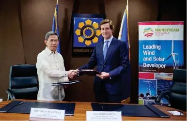  ?? PHOTO BY MAINSTREAM RENEWABLE POWER ?? Department of Energy Secretary Raphael Lotilla (left) signs an agreement for wind energy service contracts with Mainstream Renewable Power General Manager for Asia-Pacific Eduardo Karlin.