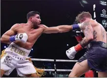  ?? (The Associated Press) ?? Tommy Fury (left) lands a punch on Jake Paul during their match Sunday in Riyadh, Saudi Arabia. Fury defeated Paul by a split decision.