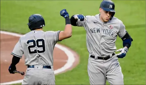  ?? Greg Fiume / Getty Images ?? Aaron Judge, right, of the Yankees celebrates with Gio Urshela after hitting a two-run homer in the second inning against the Orioles at Camden Yards in Baltimore on Saturday. Judge reached base three times in five at-bats with two hits and a walk.