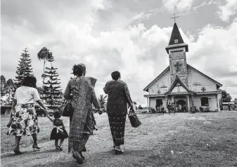  ?? Photos by Ulet Ifansasti / New York Times ?? Batak women walk to a church in Siborongbo­rong, in Indonesia's province of North Sumatra. The Batak are unhappy with the government's promotion of Muslim religious conservati­sm.