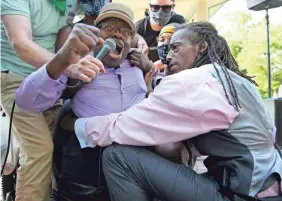  ?? KAREEM ELGAZZAR/CINCINNATI ENQUIRER ?? Robert Harris is lifted out of his wheelchair to protest the death of George Floyd at a event June 6 in Cincinnati.