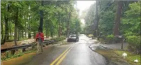  ?? SUBMITTED PHOTO ?? A motorists checks his phone after being rescued when his car got caught in flood waters on Gulph Creek Road in Radnor Monday morning. Water rescues were reported in many locations across the region.