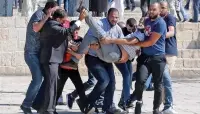  ?? MAHMOUD ILLEAN/ASSOCIATED PRESS ?? Palestinia­ns carry an injured person during Sunday clashes with Israeli police at al-Aqsa mosque compound in Jerusalem.