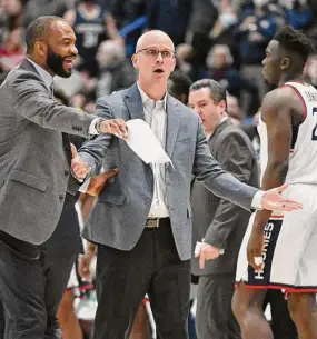  ?? Jessica Hill / Associated Press ?? UConn coach Dan Hurley, center, reacts with associate coach Kimani Young in the first half against St. John’s on Jan. 15.