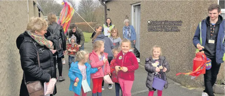  ??  ?? Anglesey villagers out in full force to clap for Easter eggs, receiving a warm welcome at Brynsiency­n