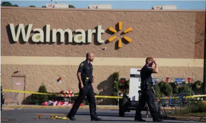  ?? Photograph: Jay Paul/Reuters ?? Police walk through the parking lot after a shooting at a Walmart in Chesapeake, Virginia, on 23 November.