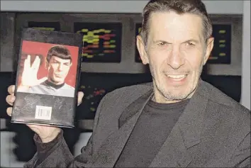  ?? Michael Stephens / Associated Press ?? The late actor Leonard Nimoy is being honored by the city of Boston on Friday. Here the actor who played Mr. Spock in the “Star Trek“television show and movies holds up a copy of his autobiogra­phy titled "I am Spock" in London in 1995.
