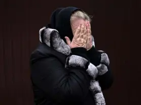  ?? Ronaldo Schemidt, AFP via Getty Images ?? Bucha resident Tetiana Ustymenko weeps over the grave of her son, buried in the garden of her house, in Bucha, northwest of Kyiv, on April 6.