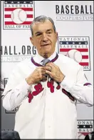  ?? ALEX BRANDON / ASSOCIATED PRESS ?? John Schuerholz buttons up his Hall of Fame jersey during baseball’s winter meetings.