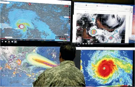  ?? PHOTO: REUTERS ?? A member of the Dominican Republic’s Emergency Operations Committee monitors the trajectory of Hurricane Irma at a control centre in the capital, Santo Domingo. The republic is one of many Caribbean nations in the path of Irma, which has been described...