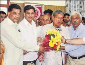  ?? HT PHOTO ?? Congress leaders present a bouquet to reinstated chief minister Harish Rawat after the Nainital high court set aside President’s rule in Uttarakhan­d, in Dehradun on Thursday.