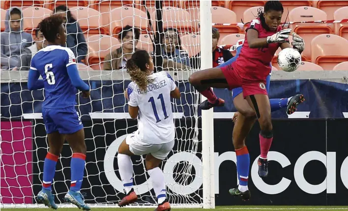  ?? AFP ?? En esta ocasión, la tica Raquel Rodríguez no pudo ganarle el balón a la portera haitiana Kerly Theus. Observa la defensora Melchie Dumomay.