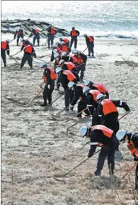  ?? KYODO NEWS VIA GETTY IMAGES ?? Police officers comb a beach in Miyagi Prefecture on Wednesday as they look for clues related to some of the thousands that went missing in the 2011 disaster.