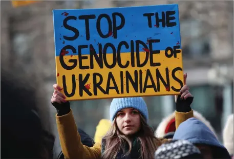  ?? NANCY LANE — BOSTON HERALD ?? A woman holds a sign reading “Stop the Genocide of Ukrainians” during a rally in Copley Sq. marking the one year anniversar­y of Russia’s invasion of Ukraine on Sunday.