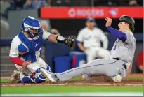  ?? THE CANADIAN PRESS FRANK GUNN ?? Colorado Rockies right fielder Michael Toglia slides in to score under the tag of Toronto Blue Jays catcher Alejandro Kirk during seventh inning interleagu­e MLB action on Friday.