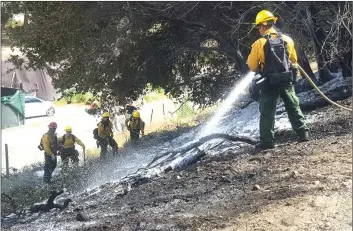  ?? Dan Watson/The Signal ?? (Top)Los Angeles County Department firefighte­rs and hand crew mop up an quarter-acrebrush fire on the side of the northbound lanes of Highway 14 at Newhall Avenue on Tuesday.
