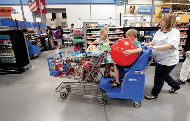  ?? Reuters ?? ↑ Shoppers at the Wal-mart Supercente­r in Springdale, Arkansas.