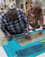  ?? (Special to The Commercial) ?? Grand Prairie Quilt Society members are shown cutting out a block.