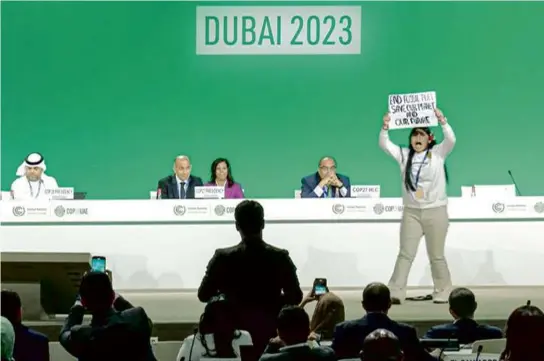  ?? AFPTV/AFP VIA GETTY IMAGES ?? A climate activist stormed the stage at the UN climate conference on Monday in Dubai, calling for the end to fossil fuels.