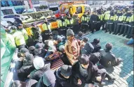  ?? KIM SUN-HO / YONHAP VIA AP ?? Members of civic groups sit around a comfort woman statue on Dec 28 in front of the Japanese consulate in Busan, South Korea.