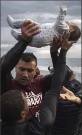  ??  ?? Rescue: A child off the coast of Lesbos