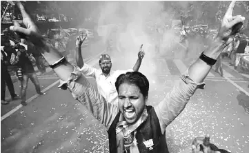  ??  ?? Supporters of BJP celebrate after learning of the initial poll results outside the party headquarte­rs in New Delhi, India. Indian shares, bonds and rupee are likely to gain when trading resumes tomorrow as Modi’s landslide victory in Uttar Pradesh is...