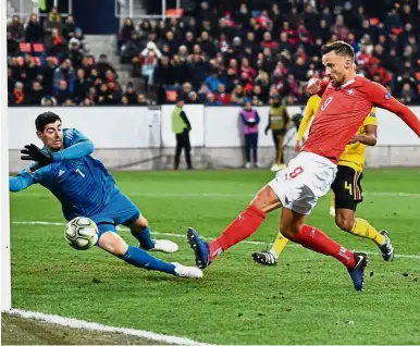  ??  ?? Take that: Switzerlan­d’s Haris Seferovic (right) scoring his team’s second goal past Belgium goalkeeper Thibaut Courtois during the UEFA Nations League Group 2 match on Sunday. — AFP