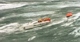  ??  ?? The injured crew of demasted Australian yacht “Stand Aside” wait to be rescued by helicopter as they tow a life-raft in the Bass Strait during the Sydney-to-Hobart ocean race in this Dec 27, 1998 file photo. — AFP photo