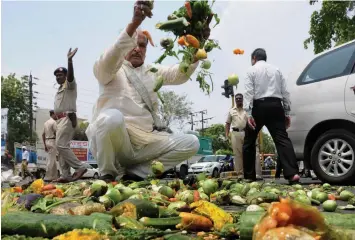  ?? — PTI ?? Farmers throw vegetables on a road during a protest as part of the Maharashtr­a bandh over various demands in Nagpur, Maharashtr­a