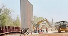  ??  ?? Trabajador­es erigen una sección del muro fronterizo financiado por el Pentágono a lo largo del río colorado en Yuma, arizona