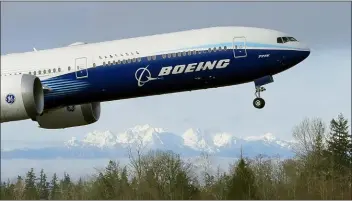  ?? TED S. WARREN — THE ASSOCIATED PRESS FILE ?? In this Jan. 25, 2020, file photo a Boeing 777X airplane takes off on its first flight with the Olympic Mountains in the background at Paine Field in Everett, Wash. Boeing announced on Wednesday it is cutting more than 12,000jobs through layoffs and buyouts as the coronaviru­s pandemic seizes the travel industry. And the aircraft maker says more cuts are coming.