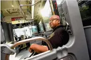  ?? REBECCA BREYER / AJC ?? Oneichan Critchlow rides the blue Cumberland Circulator bus in Atlanta on Thursday. Cobb County is considerin­g cutting local bus service in the Cumberland area less than a year after its launch as the Braves stadium circulator struggles to attract...