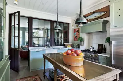  ??  ?? Right The reclaimed shopfront separates the kitchen from the sitting room; vintage verdigris pendants and a repurposed island add timeworn appeal