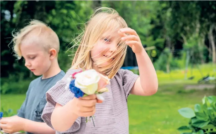  ?? ?? Vide, 7 år, och Lovina, 5 år, är med och assisterar när blomsterkr­ansarna ska bindas.
BILD: ERIK ZIENAU