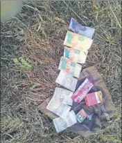  ?? HT PHOTO ?? Pakistani currency, a cigarette packet, matchbox and soft drink pouch recovered from the slain intruder.