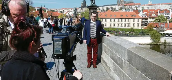  ?? FOTOS (): FILMSTUDIO SIRIUS ?? Jörg-Peter Schilling und Viola Scheler- Eckstein bei einem Interview mit Petr Hlavacek auf der Karlsbrück­e in Prag.