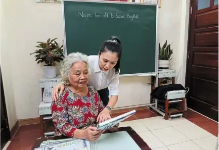  ?? ?? Keeping busy: Loc talking to yen as she attends an english class for elderly people in hanoi. — reuters