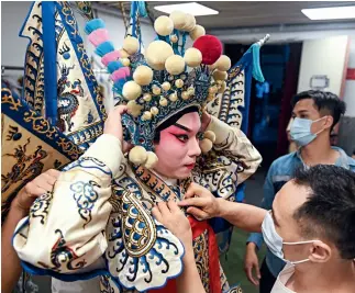  ?? Cnsphoto ?? 12 de junio de 2020. En un teatro en Guangzhou, un intérprete de ópera cantonesa viste un traje especial antes de salir al escenario.