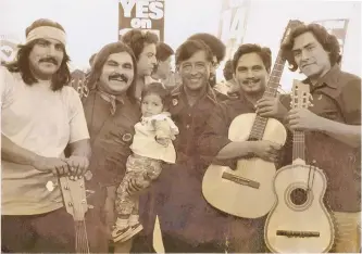  ?? COURTESY OF RAMON “CHUNKY” SANCHEZ ?? Ramon “Chunky” Sanchez (holding his daughter) with César Chávez (center), Ricardo Sanchez (at left), Enrique Ramirez (right of Chávez) and unknown musician at far right, circa 1972.