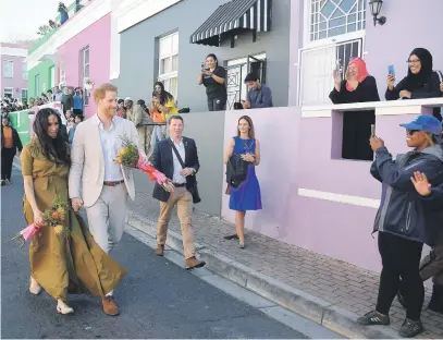  ?? Picture: Getty Images ?? CURTAIN CALL. England’s Prince Harry, Duke of Sussex, and his wife Meghan, Duchess of Sussex, walk in the Bo-Kaap district of Cape Town yesterday.