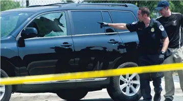  ??  ?? Investigat­ors search an automobile with a damaged driver’s window at the scene of a shooting in Alexandria, Va., involving Republican members of Congress practicing for charity baseball game.
| CLIFF OWEN/ AP