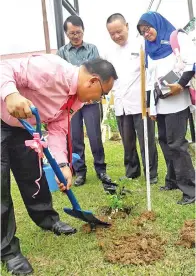  ??  ?? (Gambar kiri) ZAINI menanam pokok bunga sebagai tanda kenangan dan sokongan kepada warga SK Kolapis.