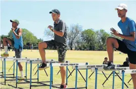  ?? Picture: BRIAN WITBOOI ?? UP AND OVER: LJ van Zyl, centre, with Emile Johannes, 18, left, and Rozario Williams, 16, both from Hangklip High School in Queenstown, during the Madibaz Athletics coaching clinic at Daniel Pienaar Technical High School in Uitenhage