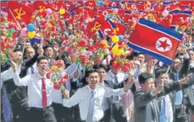  ?? REUTERS ?? People wave plastic flowers and flags during Sunday’s military parade in Pyongyang.