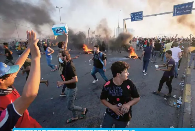  ?? —AFP ?? BAGHDAD: Iraqi protesters burn tyres during a demonstrat­ion against state corruption, failing public services, and unemployme­nt, in the Iraqi capital Baghdad.