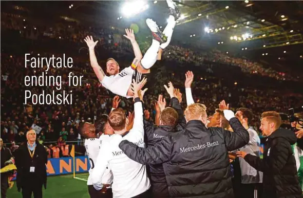  ?? REUTERS PIC ?? Germany's Lukas Podolski is tossed in the air by teammates after his final appearance for his country against England on Wednesday.